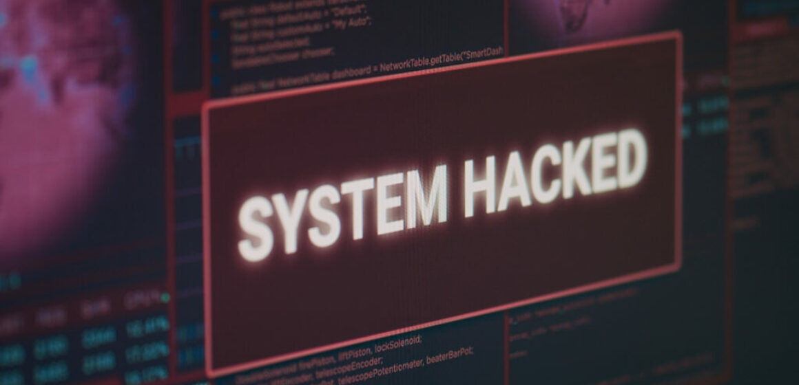 Computer monitor showing hacked system alert message flashing on screen